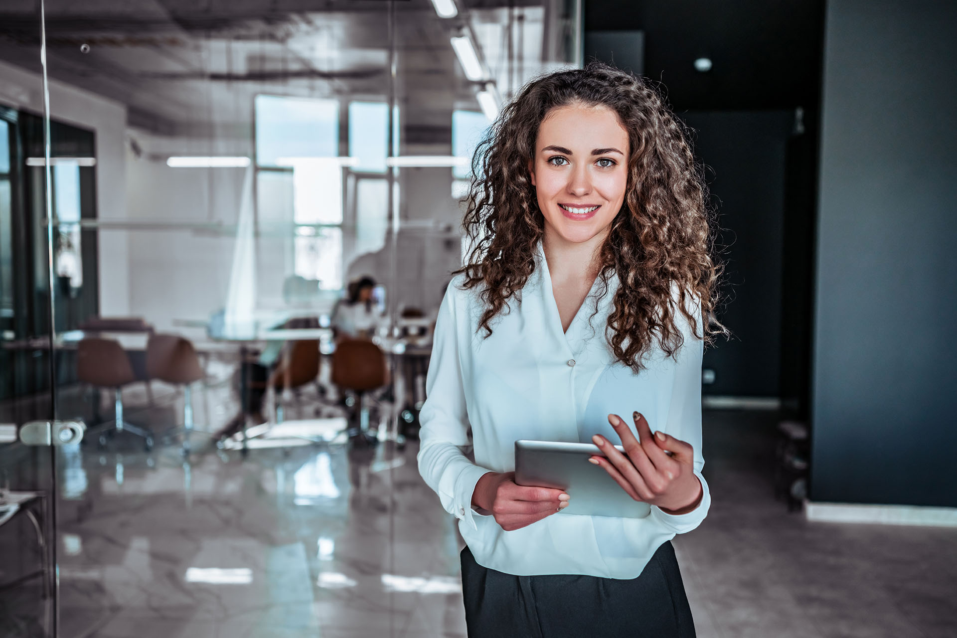 Close up of a modern business woman in a office holding an iPad.