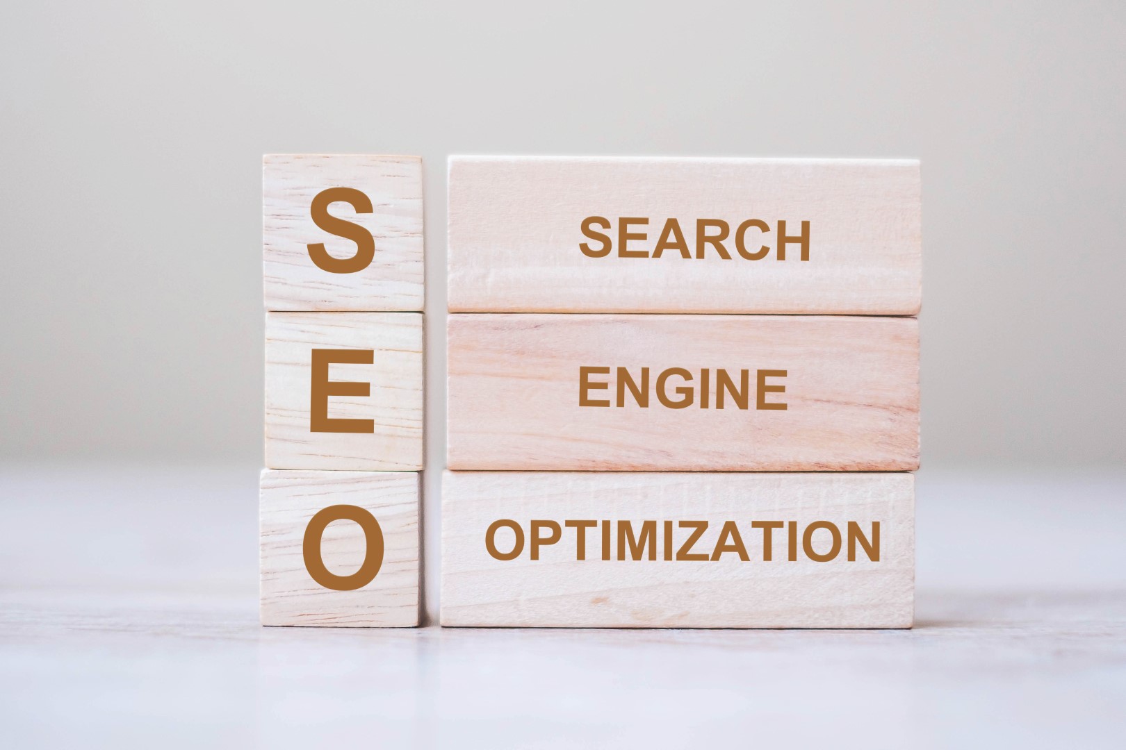 Wooden blocks that spell out “SEO,” “search,” “engine.” and “optimization.”