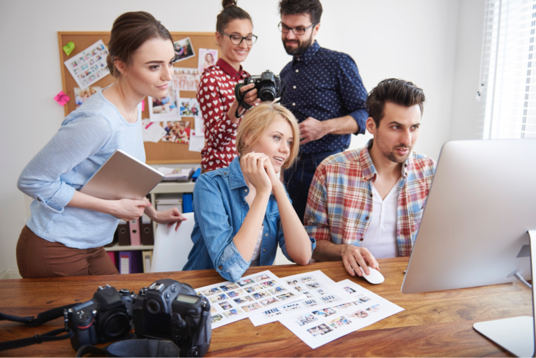 A group of coworkers looking at a computer together